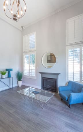 a living room with a blue chair and a glass table at Warner Center Townhomes, California, 91303