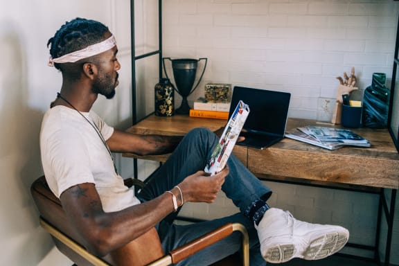a man sitting at a desk using a tablet computer