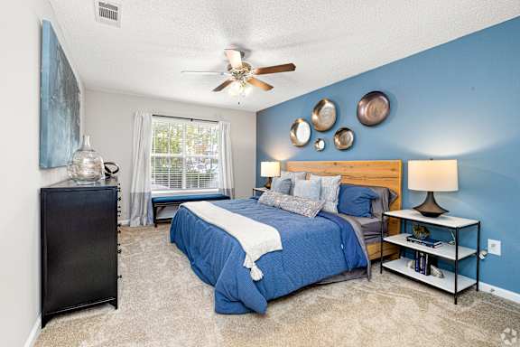 a bedroom with a bed and a ceiling fan at Park Place Apartment Homes, Hattiesburg