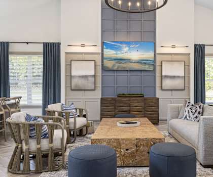 A living room with a large painting on the wall and a wooden coffee table in the center.