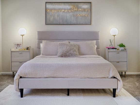 a bedroom with a bed and two nightstands with lamps