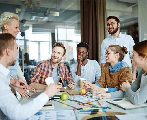 A group of people are gathered around a table, engaged in a discussion or meeting.