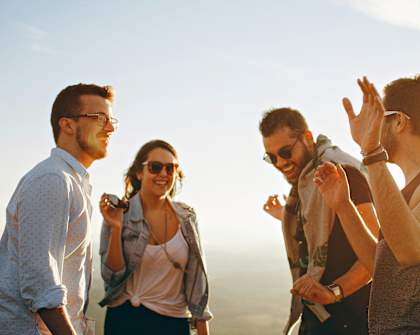 a group of people talking and laughing at the beach
