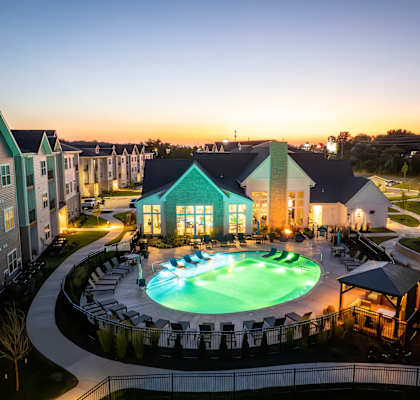 an aerial view of a resort pool at dusk at The Edison at Blue Springs, Missouri