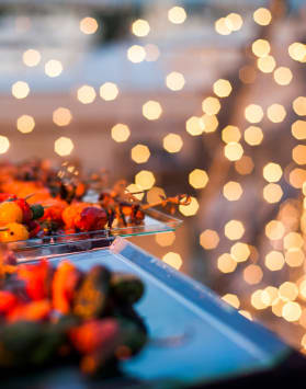 a table of food with lights in the background