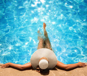 Woman with sunhat relaxing in pool 