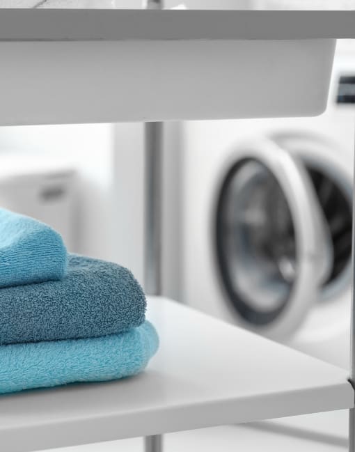 a stack of towels in front of a washing machine