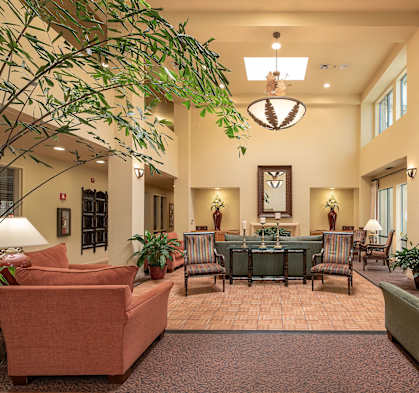 a lobby with couches and chairs and a table in the middle at Winding Commons Senior Living, Carmichael, CA, 95608