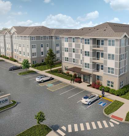 A large apartment complex with a parking lot in front.