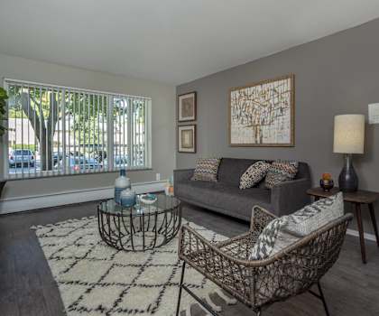 a living room with a couch and two chairs and a window