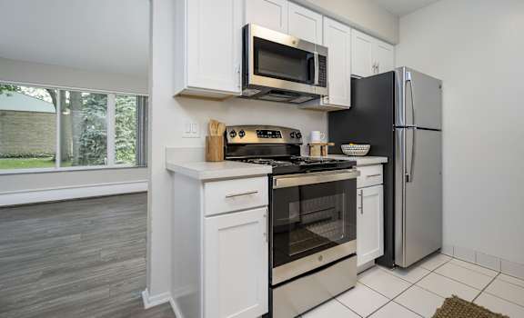 a kitchen with white cabinets and a stainless steel refrigerator