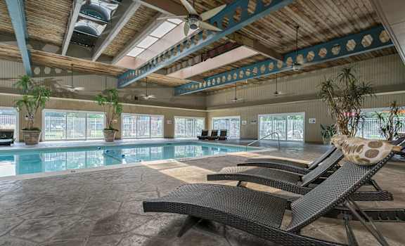 a swimming pool with two lounge chairs