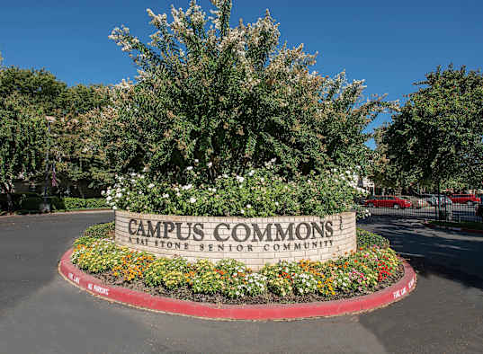a sign for campus common at the front entrance of a parking lot