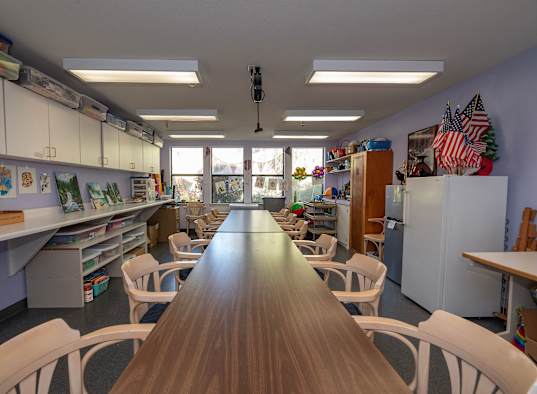 a classroom with a long table and chairs and a window at Hilltop Commons Senior Living, Grass Valley