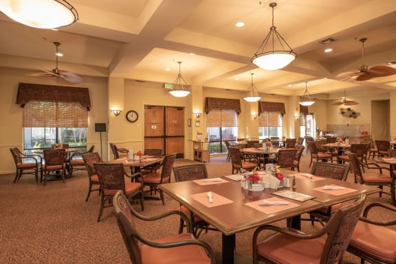 a large dining room with tables and chairs and windows