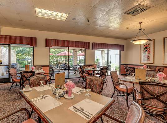 a dining room with tables and chairs and windows