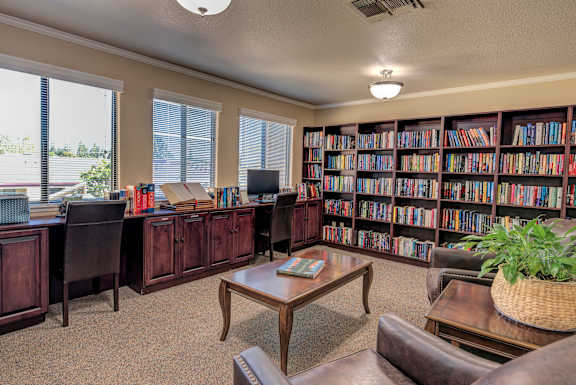 a library with a desk and shelves filled with books