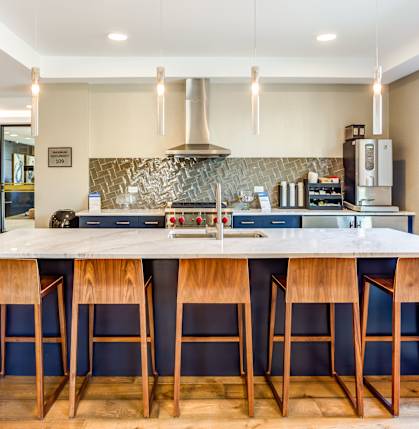 A kitchen with a bar area and a stove top oven.