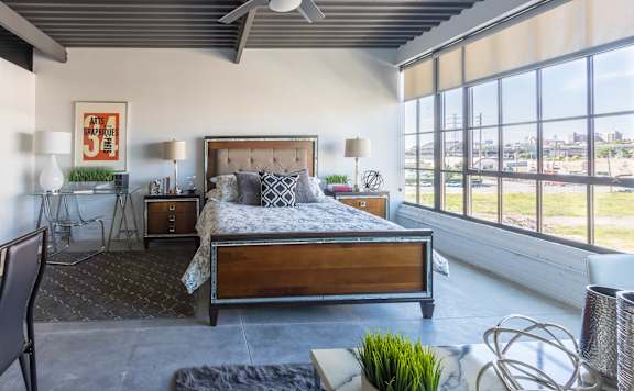 A bedroom with a large bed and a view of the city.