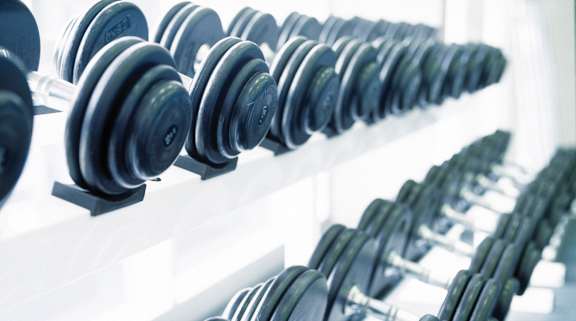 A row of dumbbells are lined up on a rack at Pleasantview Apartments, Baltimore, Maryland
