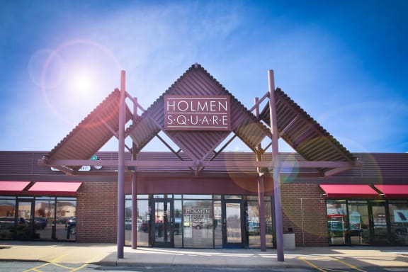 the exterior of a hollien square store with a red facade and a sign