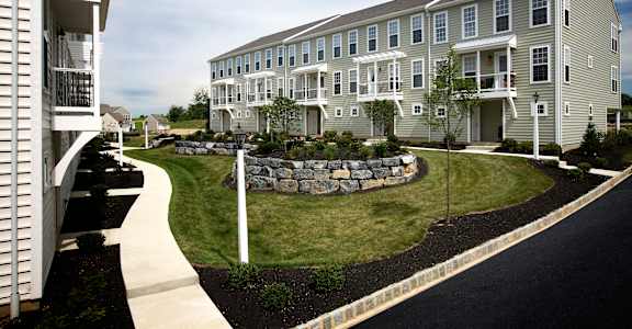 an exterior view of an apartment building with a landscaped yard