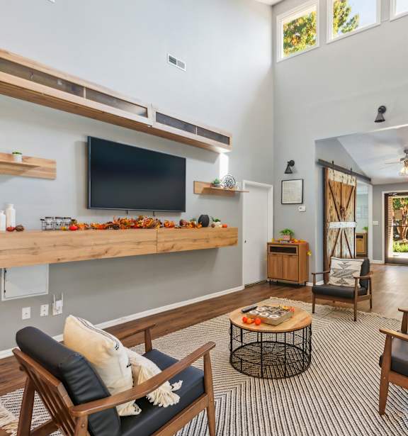 A living room with a television, a chair, and a table.