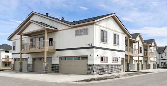 A modern two-story house with a balcony on the second floor.