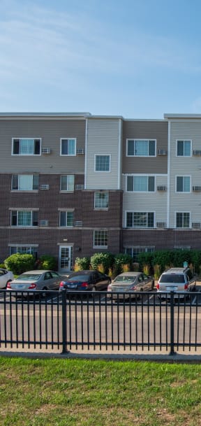 a large apartment building with cars parked in front of it
