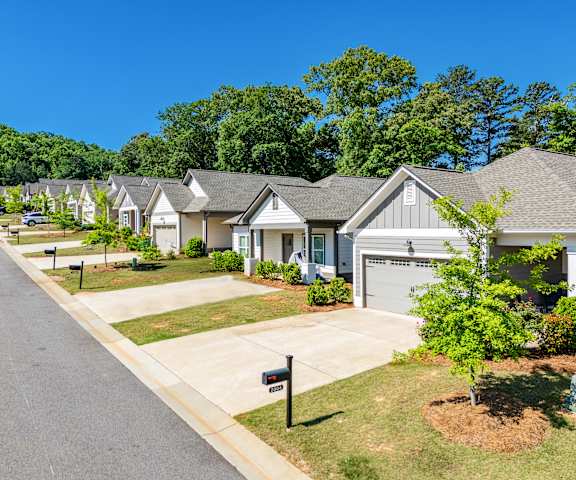 A row of houses with a tree in front of the first house.