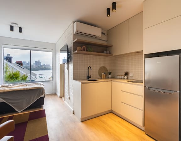 a kitchen with white cabinets and a large window