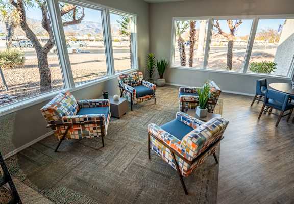 A sunny room with a couch, chair and table.