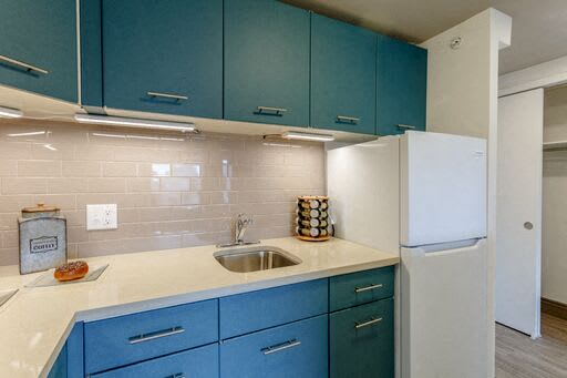 A white stove and refrigerator in a kitchen with brown cabinets.