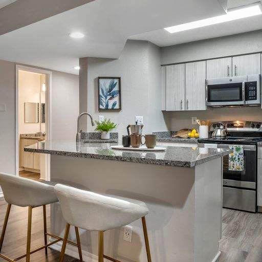 A kitchen with a granite countertop and white cabinets.