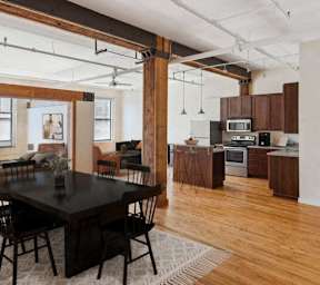 A modern kitchen with wooden floors and a dining table with chairs.at Lee Lofts, Minneapolis, MN 55401