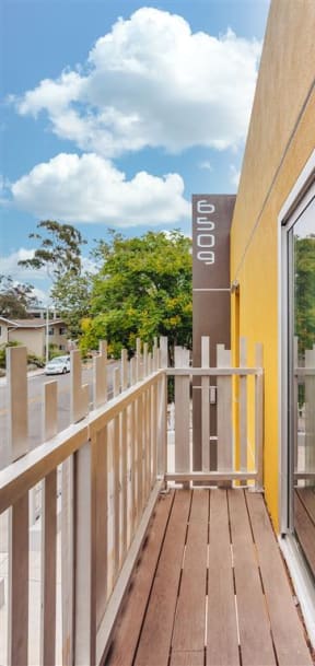 a balcony with a wooden floor and a glass door