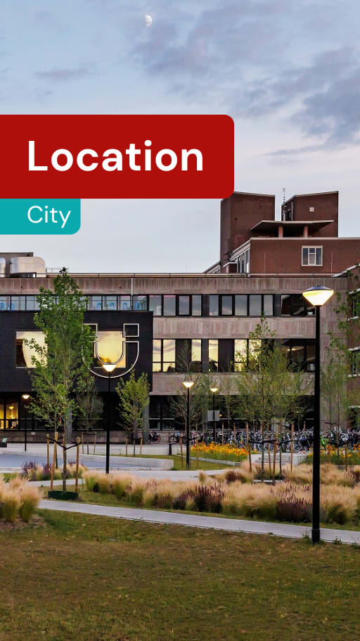 A modern building with a grassy area in front and a red sign that says "Location City".