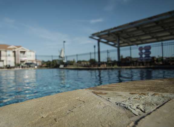 A view of a pool with a building in the background.