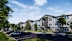 A modern apartment complex with a parking lot in front.