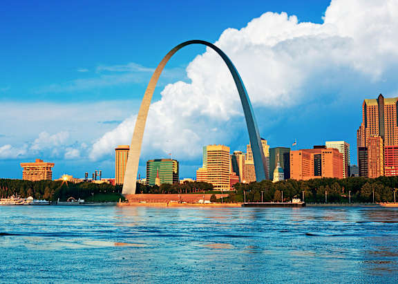 A city skyline with a large arch structure in the foreground.
