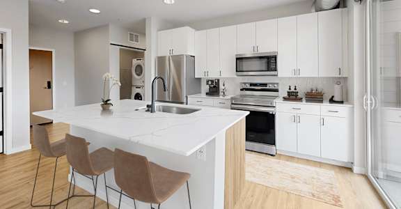 A modern kitchen with white cabinets and a large island.