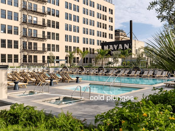 A pool area with lounge chairs and a sign that says  at Olympic + Hill Apartments, Apartments, Los Angeles, CA