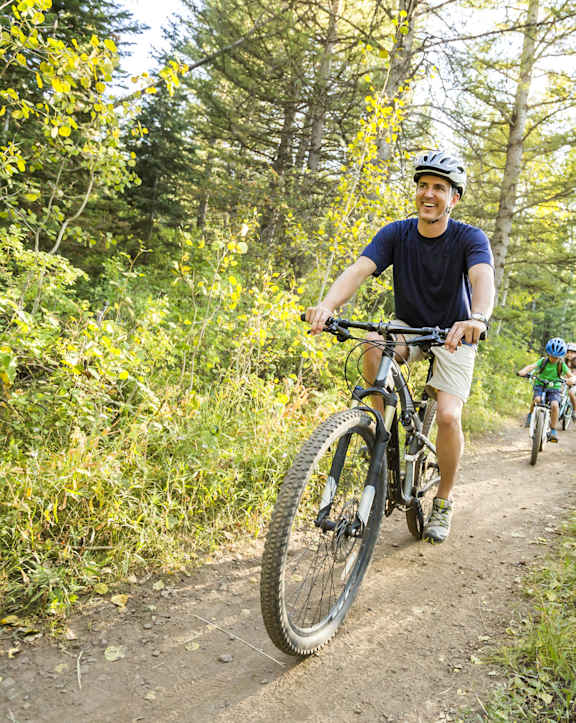 A man riding a mountain bike on a trail in the woods.