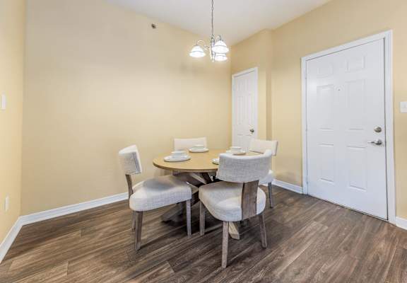 A dining room with a table and chairs.