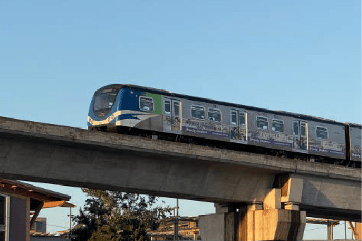 A train is on a bridge with a clear blue sky in the background.