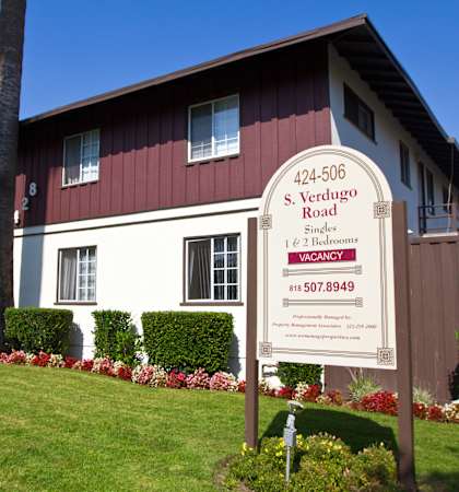 a red and white house with a sign in front of it
