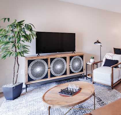 a living room with a couch and a chair and a kitchen