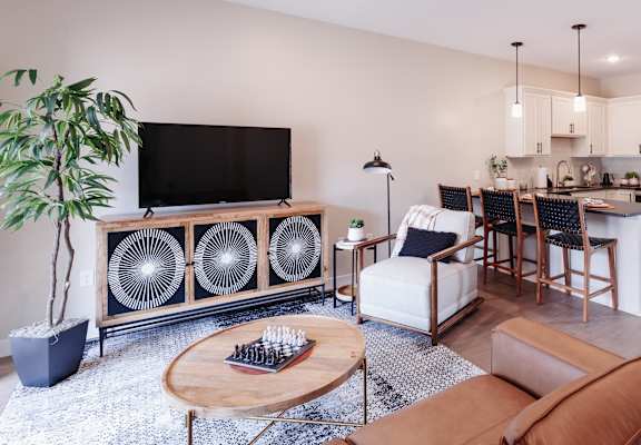 a living room with a couch and a chair and a kitchen