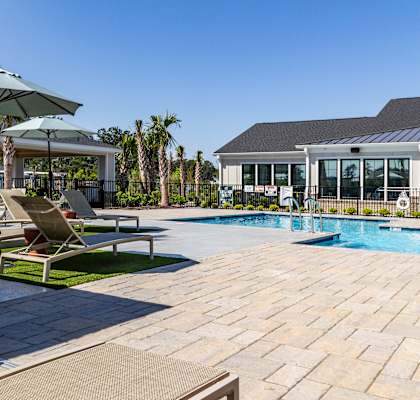 A pool area with a sun lounger and umbrella.