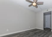 Thumbnail 6 of 22 - an empty living room with wood flooring and a ceiling fan